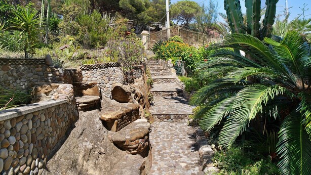 A stone pathway leading uphill, surrounded by lush greenery and cacti. - Villa 'Capriccio' with Sea View, Private Terrace and Private Garden (Bordighera)