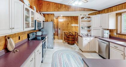 View-worthy home lined by trees with a fireplace, wrap-around deck, grill, & W/D