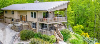 View-worthy home lined by trees with a fireplace, wrap-around deck, grill, & W/D