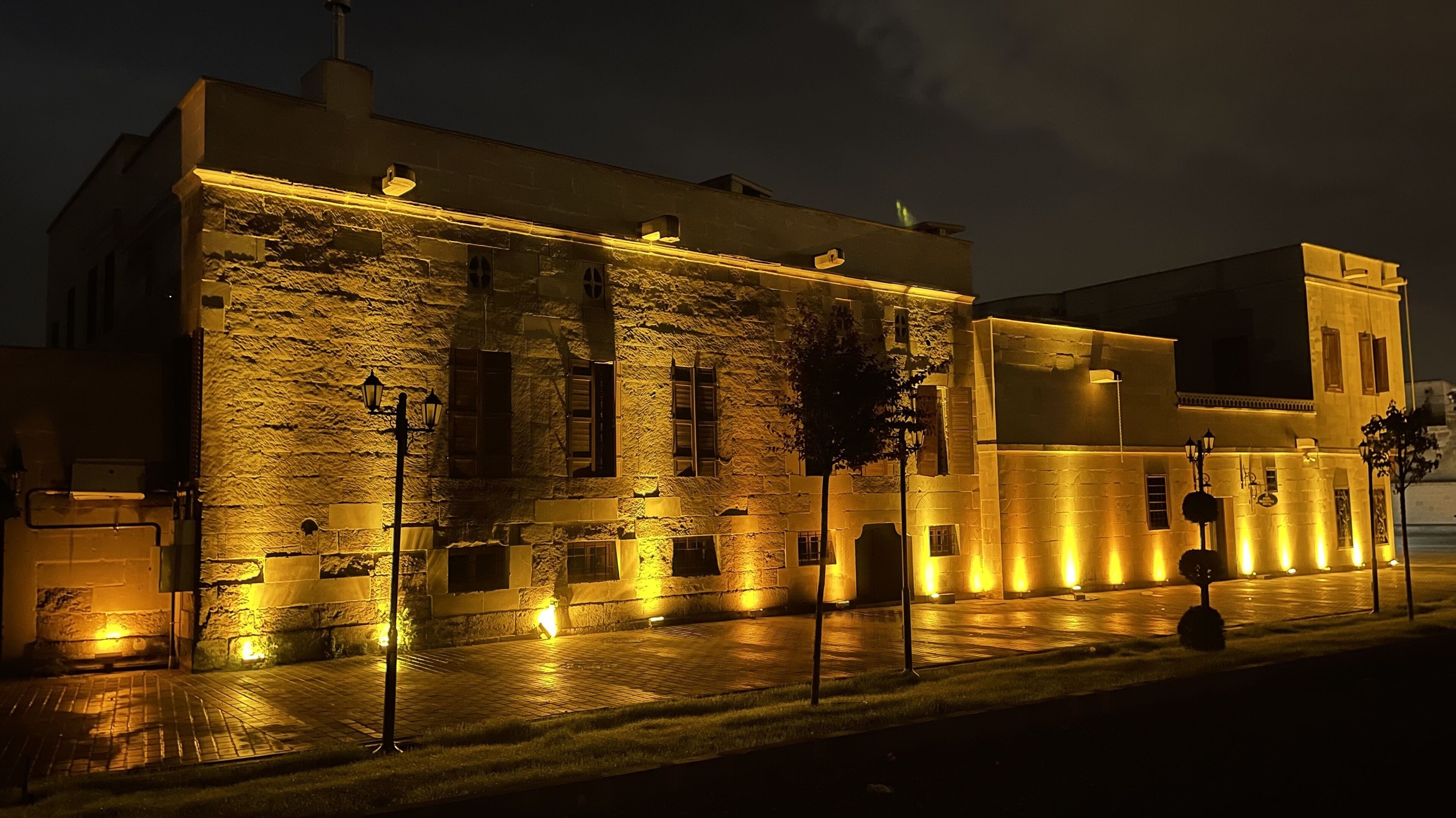 Un edificio con fachada de piedra e iluminación cálida.