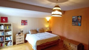 A bedroom with a wooden bed, a bookshelf, a lamp, and a wall-mounted artwork. - Villa Provençale aux Portes D'avignon (Villeneuve-lès-Avignon)