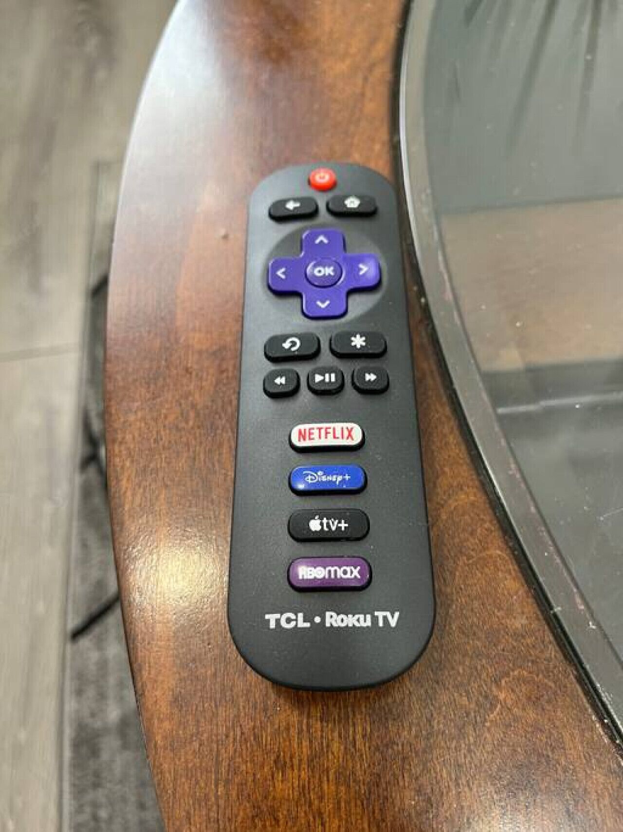 Kaukosäädin, jossa on painikkeet Netflixiä, Disney+:ää, Apple TV+:ää ja Roku TV:tä varten.