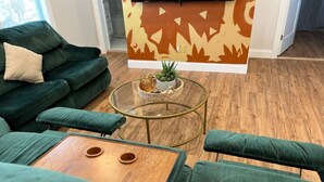 A green sofa set with a glass coffee table and a small wooden side table. - Local Artist Inspired | Walk to WestPoint + King Bed (Highland Falls)