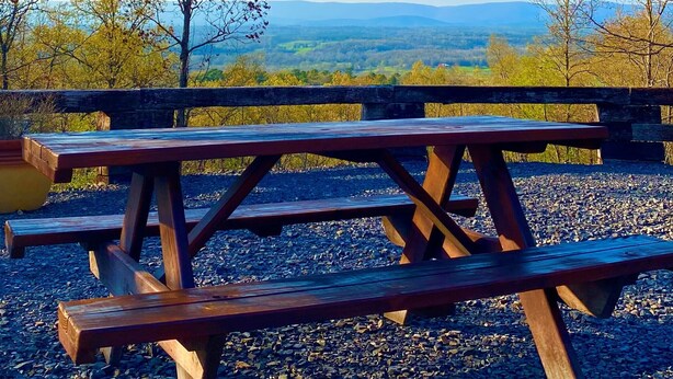 Ein Picknicktisch mit Blick auf eine gebirgige Landschaft.