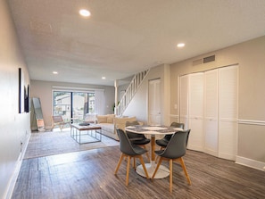 Relax in this spacious living area with a round dining table and comfortable seating for four.