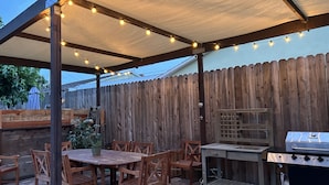 An outdoor patio with a covered seating area, a grill, and string lights. -  Eastside Costa Mesa, close to Disneyland, beaches.
1.5 miles to JWA airport. (Costa Mesa)