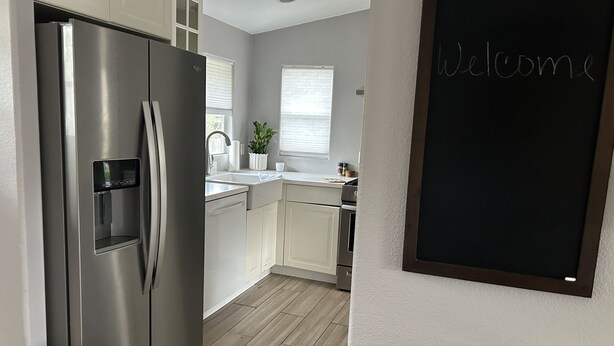 A modern kitchen with stainless steel appliances, a water dispenser, and a chalkboard with "Welcome" written on it. -  Eastside Costa Mesa, close to Disneyland, beaches.
1.5 miles to JWA airport. (Costa Mesa)