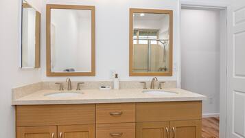 A bathroom with two sinks, wooden cabinets, and two mirrors.