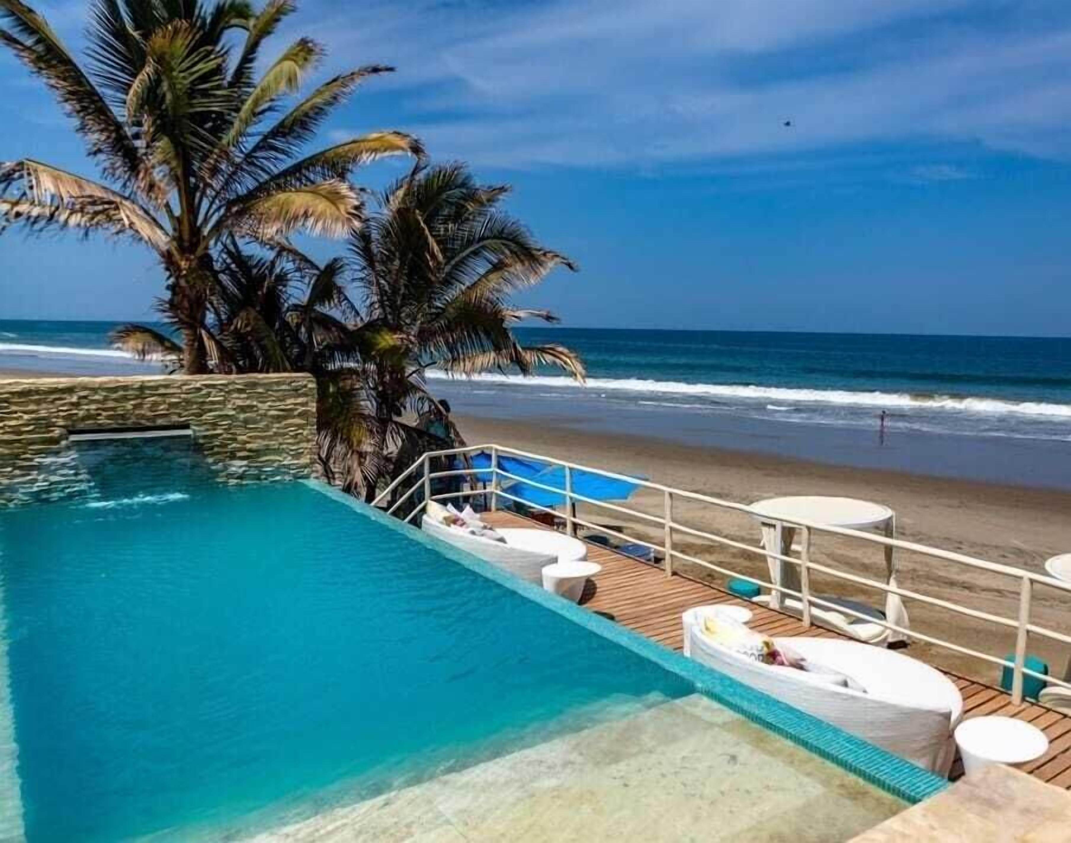 An infinity pool with a view of the beach and ocean.