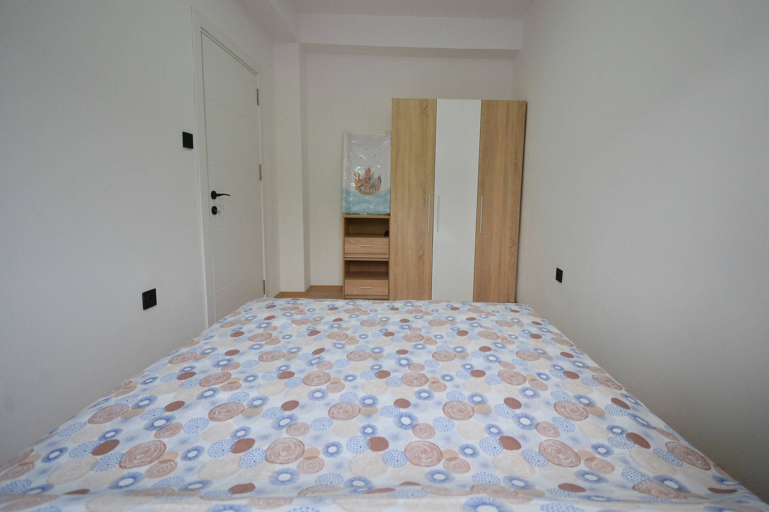 Une chambre à coucher avec un lit, une armoire et une porte.