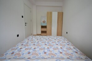 A bedroom with a bed, a wardrobe, and a door.