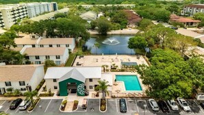 A hotel with a swimming pool, a parking lot, and a river in the background. - Townhouse | USF - Moffitt - AdventHealth - Busch Gardens (Tampa)