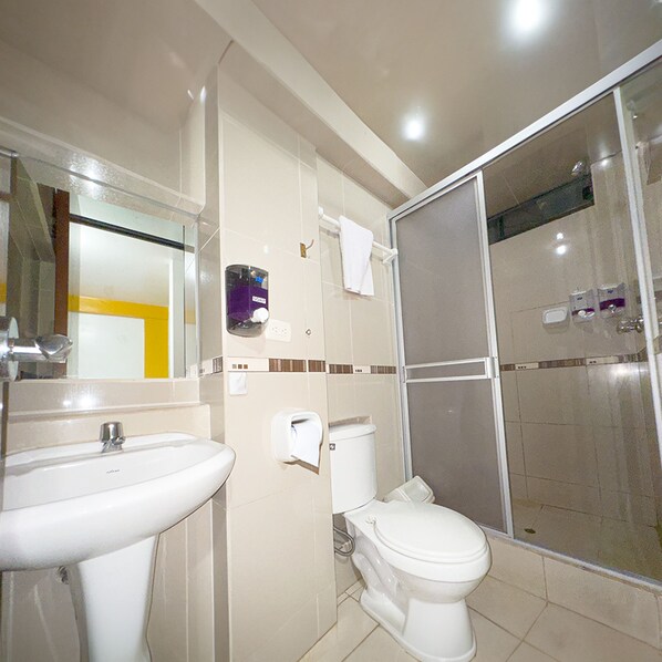A bathroom with a sink, toilet, and shower area.