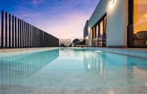 Relax by the pool surrounded by a serene atmosphere and a contemporary building.