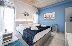 Relax in a serene bedroom with a large bed, bedside table, and a potted plant.