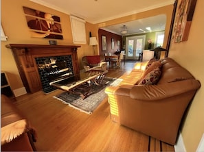Uma sala de estar aconchegante com lareira, um sofá de couro e um espaço de jantar com mesa e cadeiras.