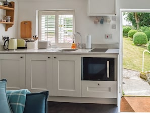 Cocina con ventana, pileta y vista a un jardín.