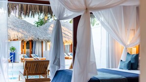 A bedroom with a bed, a wooden chair, a pool area, and a thatched-roof structure. - MKNI Hotel - Makani Experience (Acaraú)