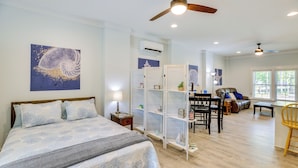 Un dormitorio con cama, ventilador de techo y mesita de noche.