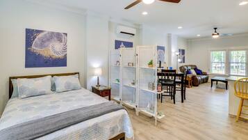 A bedroom with a bed, a ceiling fan, and a nightstand.