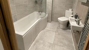 A modern bathroom with a freestanding bathtub, a toilet, and a sink. - Oakham hotel (Oakham)