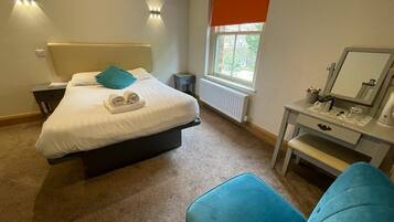 A bedroom with a bed, bedside table, and a chair.