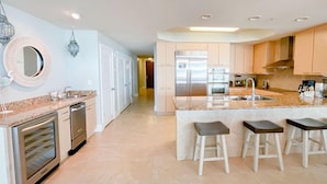 A modern kitchen with a central island, stainless steel appliances, and a light-colored floor. - DOWN BY THE BAY! 3RD FLOOR 2 BEDROOM 2 BATH UNIT!! ASK ABOUT DISCOUNTS! (Orange Beach)