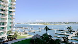 A high-rise hotel with multiple balconies overlooking a marina with boats and a clear blue sky. - DOWN BY THE BAY! 3RD FLOOR 2 BEDROOM 2 BATH UNIT!! ASK ABOUT DISCOUNTS! (Orange Beach)