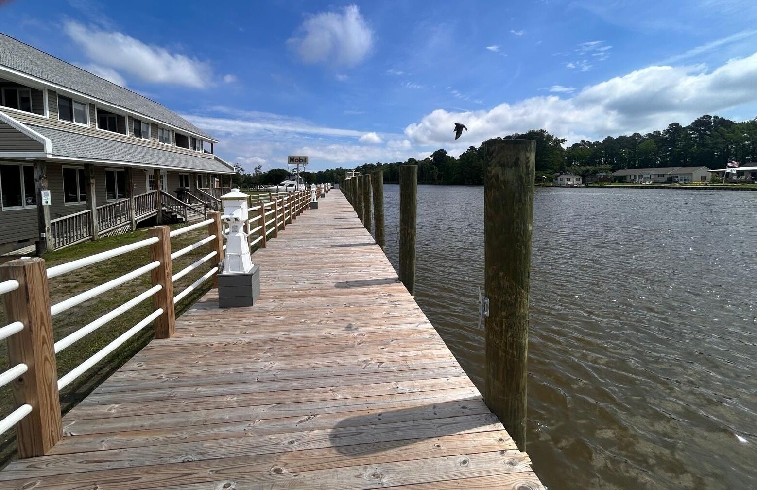 A wooden pier extending into a body of water with a building on the left side.