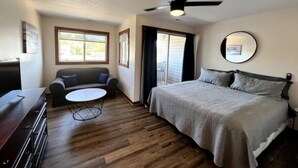 A bedroom with a bed, a ceiling fan, a window, and a door leading to a balcony. - Knot Two- Balcony View of ICW- Dog Friendly (Coinjock)