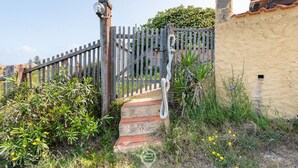 Un escalier en bois mène à une porte surmontée d’une sculpture de serpent.