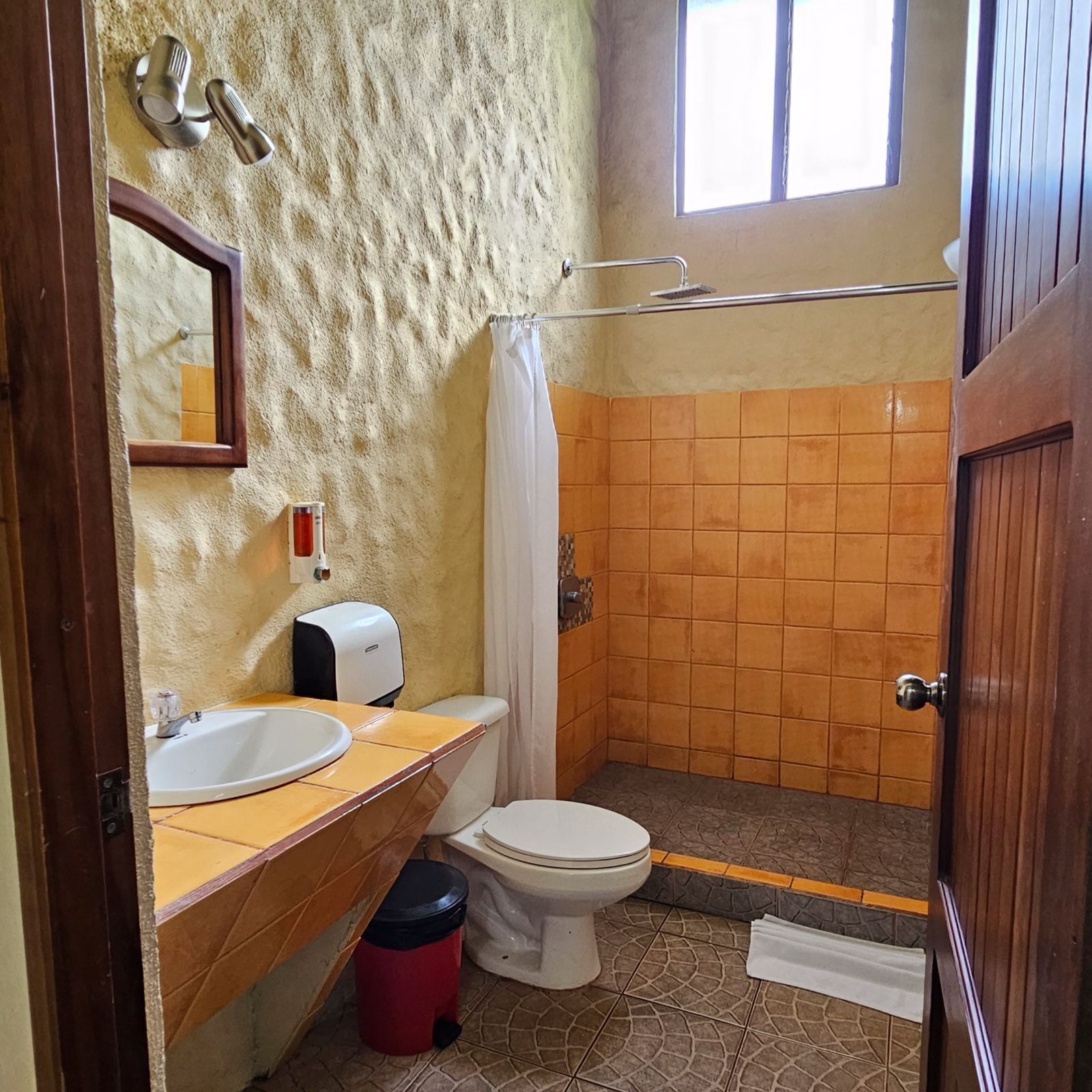 Een badkamer met een wastafel, toilet en douchehoek.