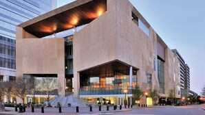 A modern building with a large overhang and multiple floors.