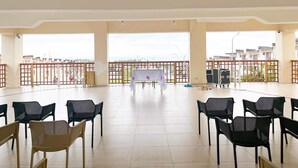 A spacious indoor area with a balcony, a table with a white tablecloth, and several chairs. - Townhouse with a pool, arcade/gaming area and a massage chair! (City of Naga)
