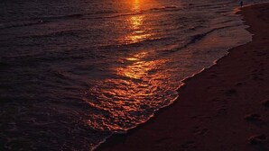 A sunset over the ocean with a beach in the foreground. - Enjoy easy beach access and awesome bay views as soon as you step out the studio (Provincetown)