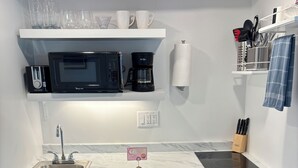 A kitchen with a built-in dishwasher, a microwave, and a coffee maker. - Enjoy easy beach access and awesome bay views as soon as you step out the studio (Provincetown)