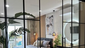 A modern bedroom with a bed, bedside table, and a large window. - Casa Benita (Hvar)