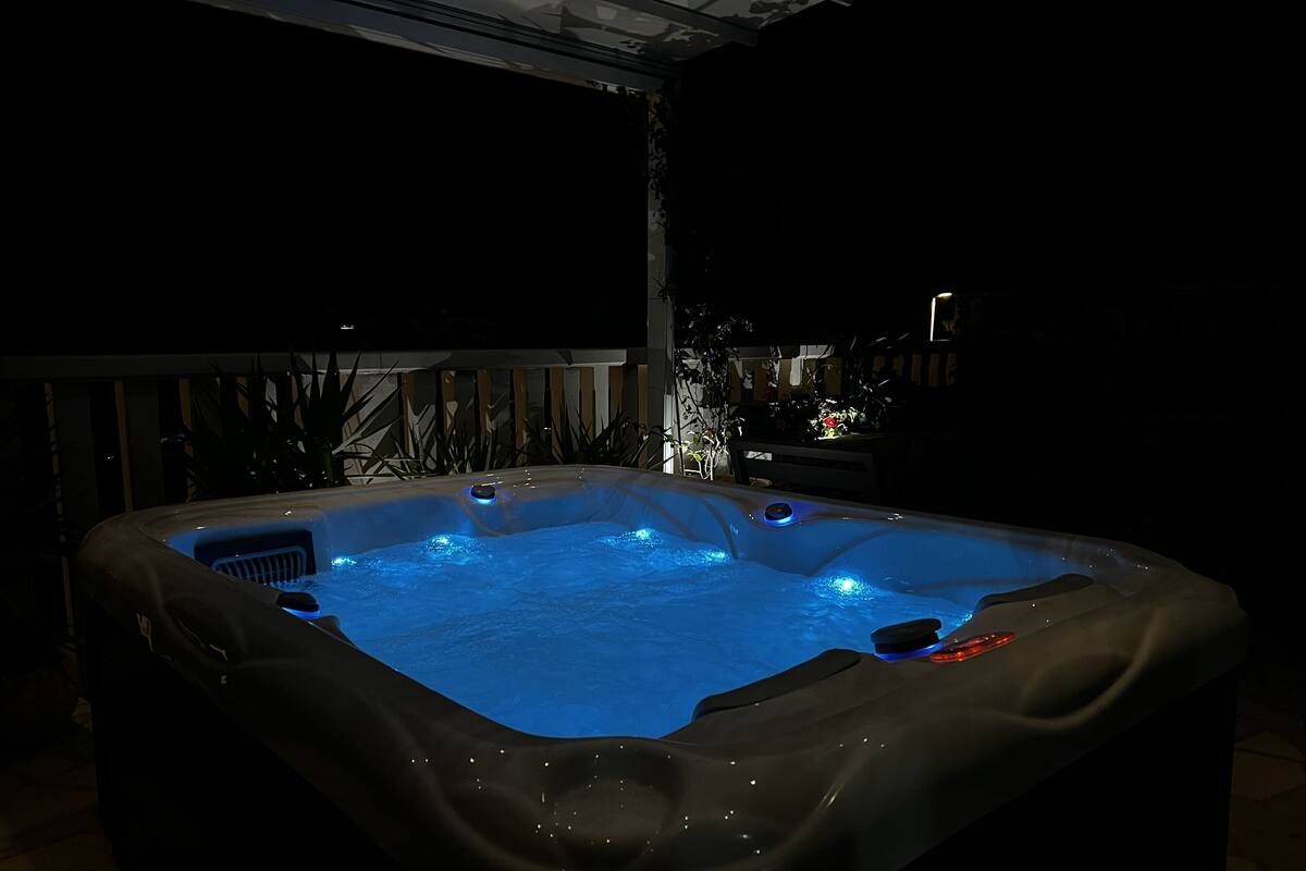 Un jacuzzi con calentador integrado y una mesita auxiliar al lado.