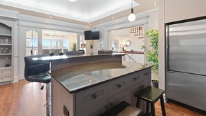 Una cocina moderna con una isla grande, electrodomésticos de acero inoxidable y vistas a la ciudad.