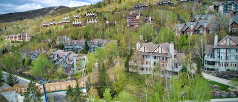 A hillside resort with multiple chalet-style buildings, a ski lift, and a road winding through the area.
