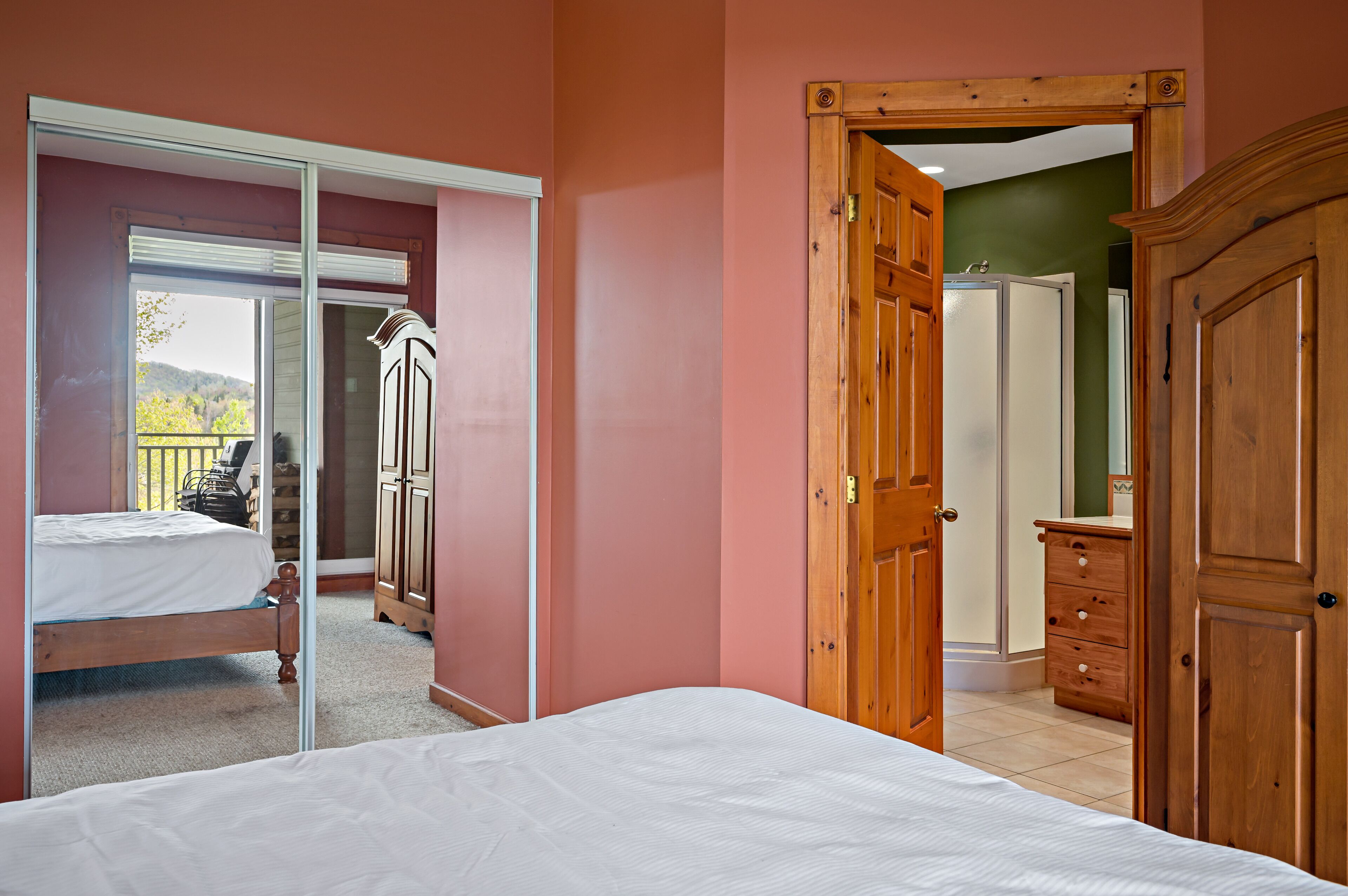 Un dormitorio con cama, armario y puerta que da a un baño.