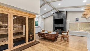 A spacious room with a wooden sauna, a fireplace, and a comfortable seating area. - Blue Skies Retreat - Custom-Built Retreat in the Suburbs! (Farmington Hills)