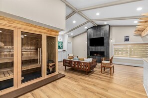 A spacious room with a wooden sauna, a fireplace, and a comfortable seating area.