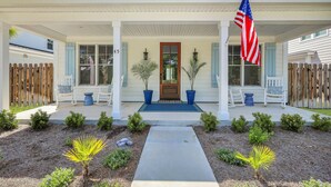 Een tweelaags huis met een veranda, een voordeur en een Amerikaanse vlag.
