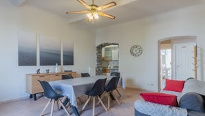 A dining area with a table, chairs, and a ceiling fan.