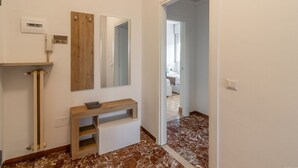 Een badkamer met een wastafel, spiegel en houten opbergmeubel.
