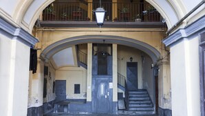 A building entrance with a balcony, a staircase, and a door.