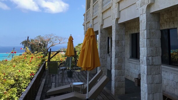 A stone building with arched windows and a balcony overlooking a scenic view. - Ocean View Capitol Hill Studio with Sunset Deck (Capitol Hill)