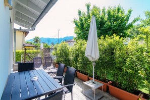 Relax in the serene outdoor patio surrounded by lush greenery and breathtaking mountain views.