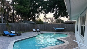 A swimming pool with a tiled edge, surrounded by a brick patio. There are lounge chairs and a hammock. - 3-bedroom vacation home just 9 minutes from Port Canaveral (Merritt Island)